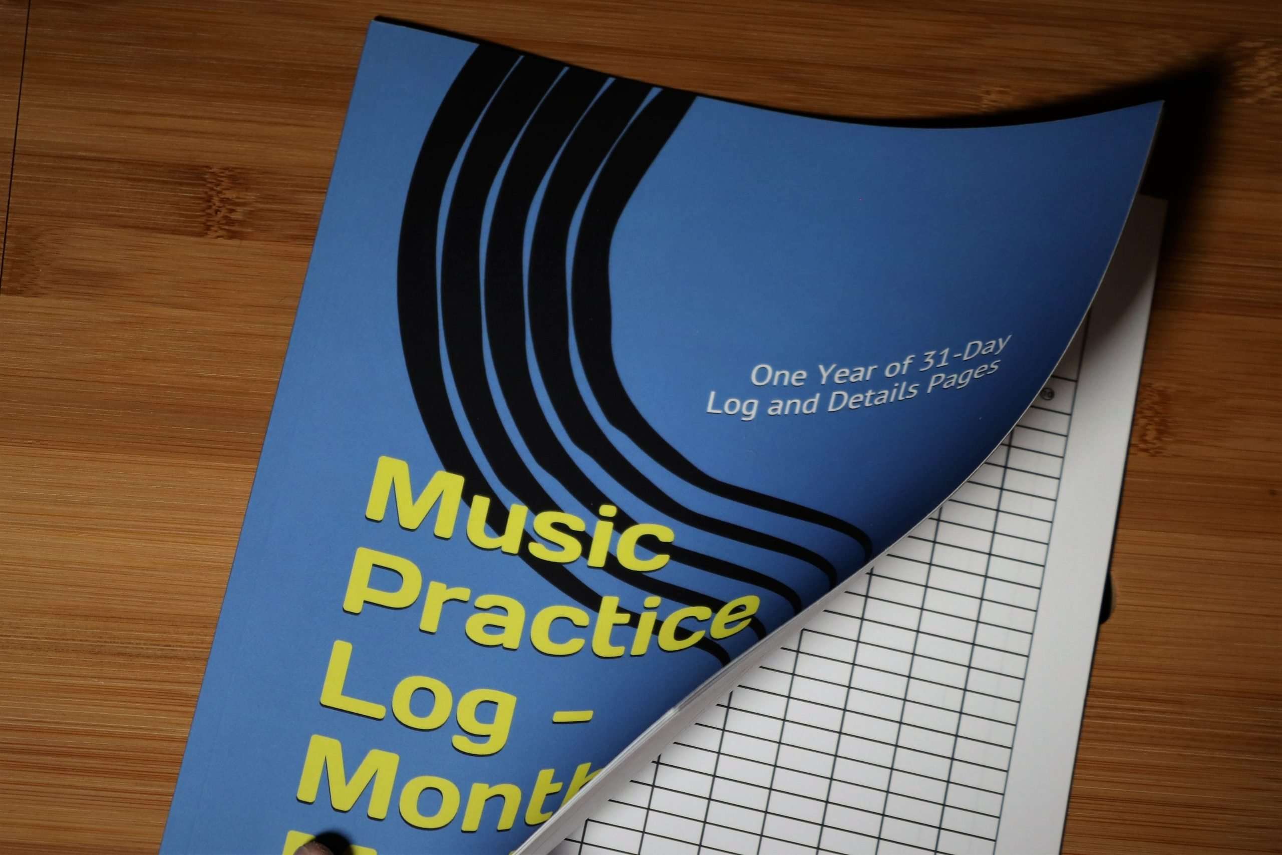Music Practice Log - Month by Month held open on a desk