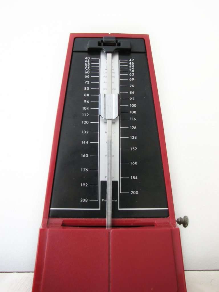 Stationary red analog metronome