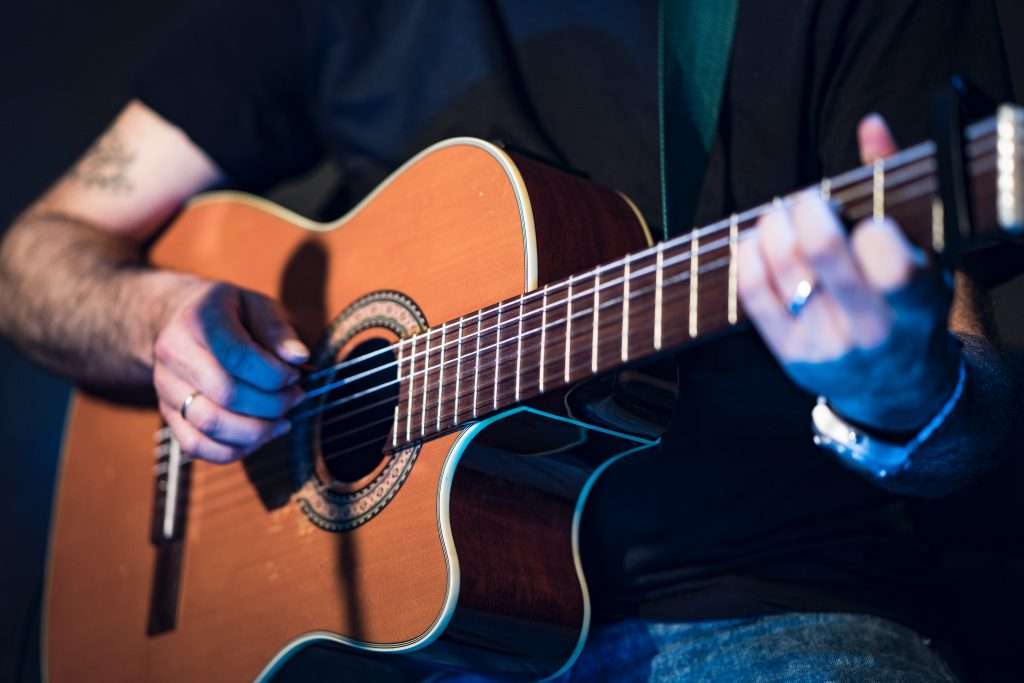 Man playing inexpensive beginners guitar